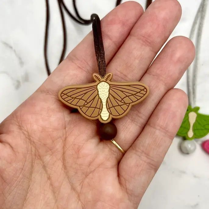 The brown chewy Moth Fidget Chewable Jewelry Necklace.