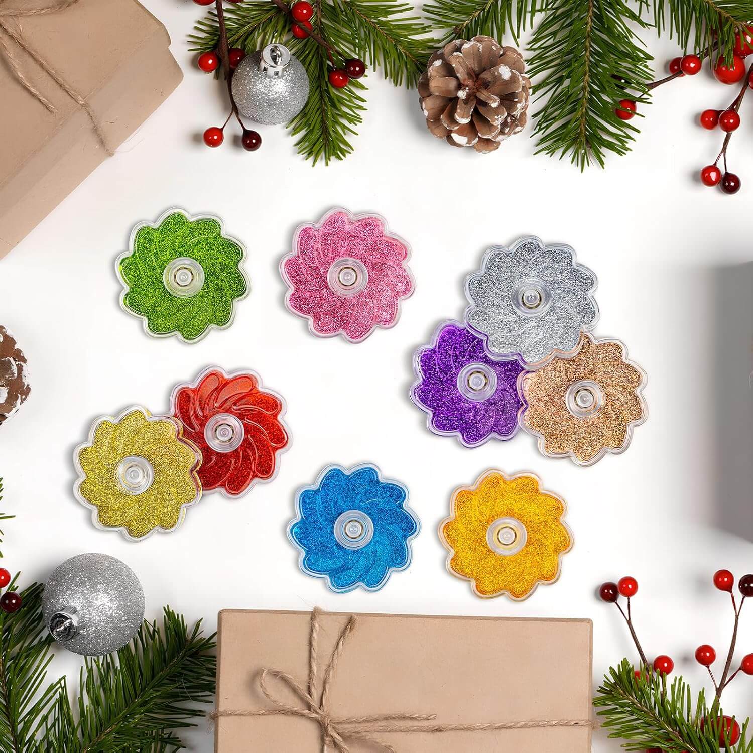 The different colors of the Glitter Petals Fidget Spinner are spread out next to holiday flora.