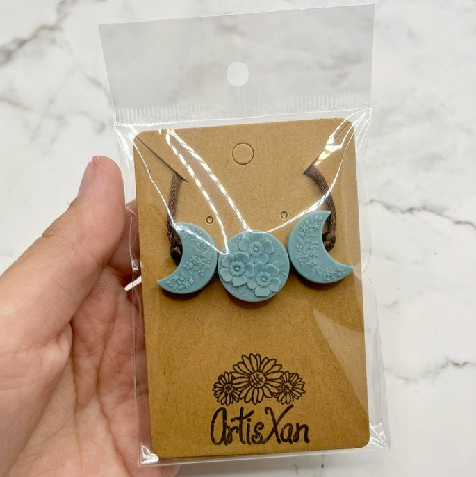 The Blue Crescent Moon Phases Fidget Necklace.