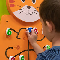 An up close look at a child moving a number tile on the Cat Activity Wall Panel.