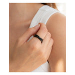 A hand models the Mint & Lily Black Dainty Interlocking Fidget Ring.