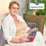 An older woman sits with the Blue Fidget Wrist Cuff open on her lap.