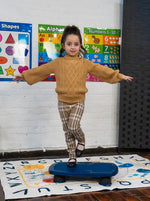 A child balances on the Bouncy Board by Bouncyband with one leg.