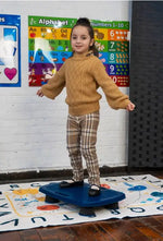 A child stands on the Bouncy Board by Bouncyband.