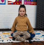 A child sits on the Bouncy Board by Bouncyband.