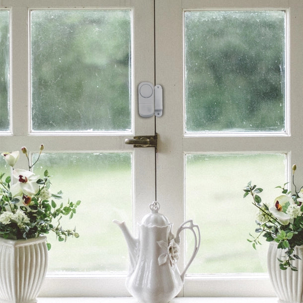 The Mini Entry Alarm System on a window pane.