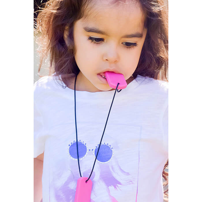 A child wears the Hot Pink ARK Chewable Dog Tag Necklace.