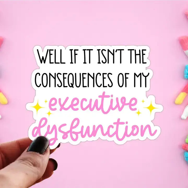A hand holds up a sticker that reads: Well if it isn't the consequences of my executive dysfunction.