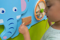 A child with light skin tone plays with the wooden panel on the Elephant Activity Wall Panel.