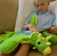 A child reads a book with the Barmy Dinosaur Weighted Lap Pad.