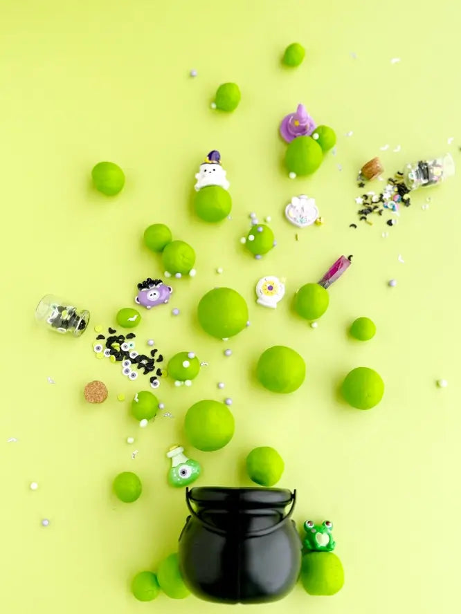 The Poison Apple scented dough is rolled into different sized balls, mirroring bubbles, and shown floating  out of a cauldron.