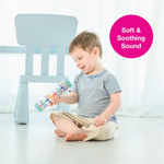 A toddler sits cross legged and holds the Rainstick 8" up.