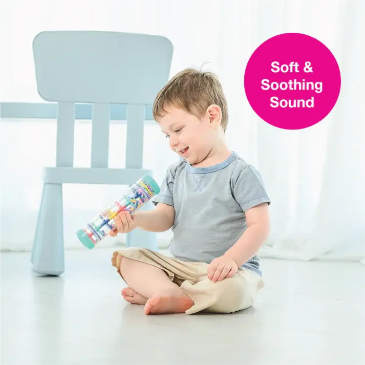 A toddler sits cross legged and holds the Rainstick 8" up.