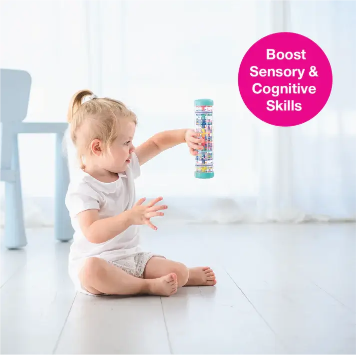 A toddler sits on the floor and holds the Rainstick 8" up.