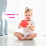 A child holds the red strawberry scented ball.