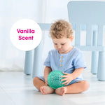 A child holds the mint green vanilla scented ball.