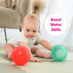 A baby pushes the Scented Sensory Balls and moves towards them.