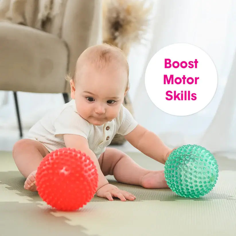 A baby pushes the Scented Sensory Balls and moves towards them.