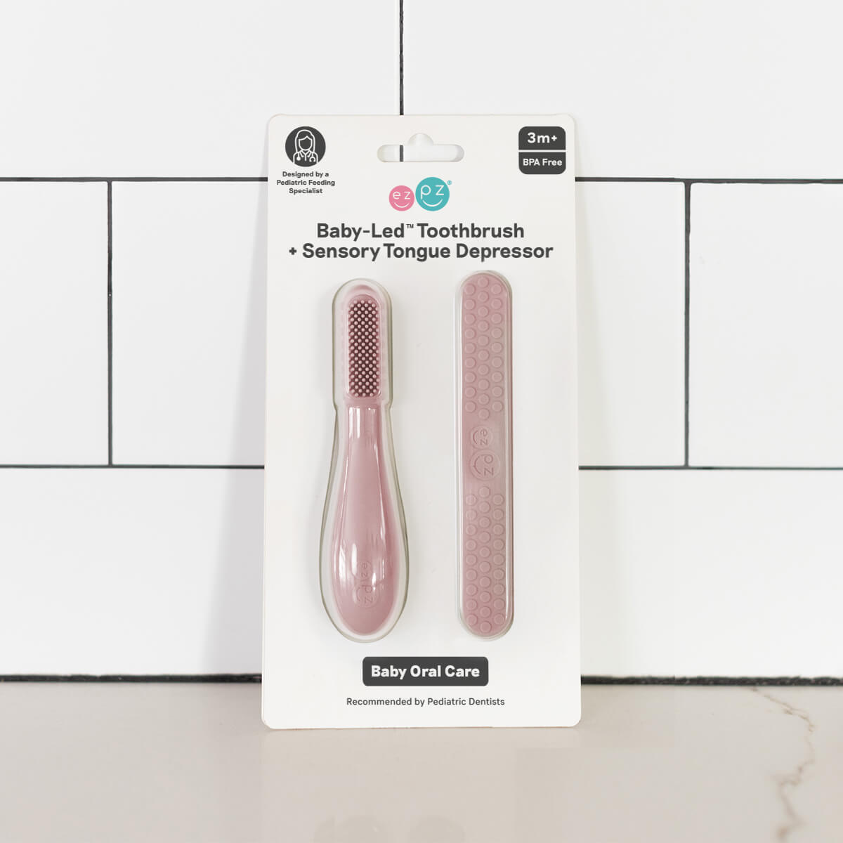The Blush ezpz Baby-Led Toothbrush and Tongue Depressor Combo.