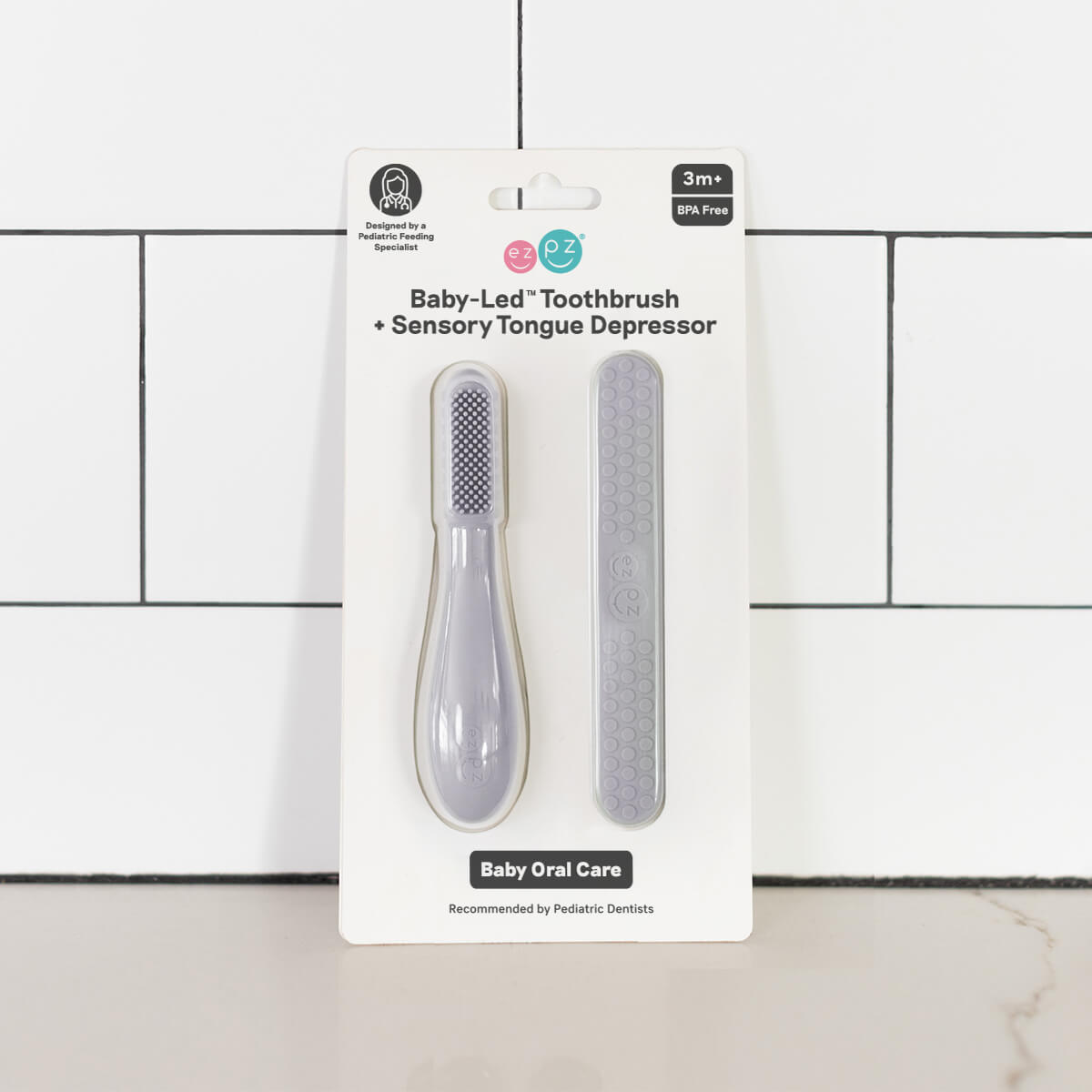 The Pewter Baby-Led Toothbrush and Tongue Depressor Combo in its product package.