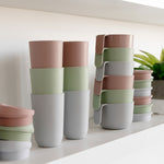The different colors of the 14 oz Cup + Lid stacked in a visually appealing way.