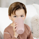 A child sups from the Blush 14 oz. Cup + Lid by ezpz.