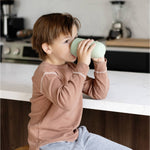 A child drinks from the Sage Cup.