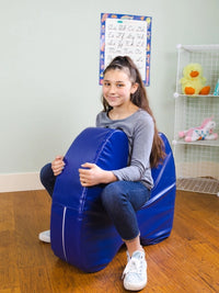 A child with light skin tone and a long brown ponytail sits inside of the Sensory Soft Squeeze Seat by Bouncyband like it is a pony.