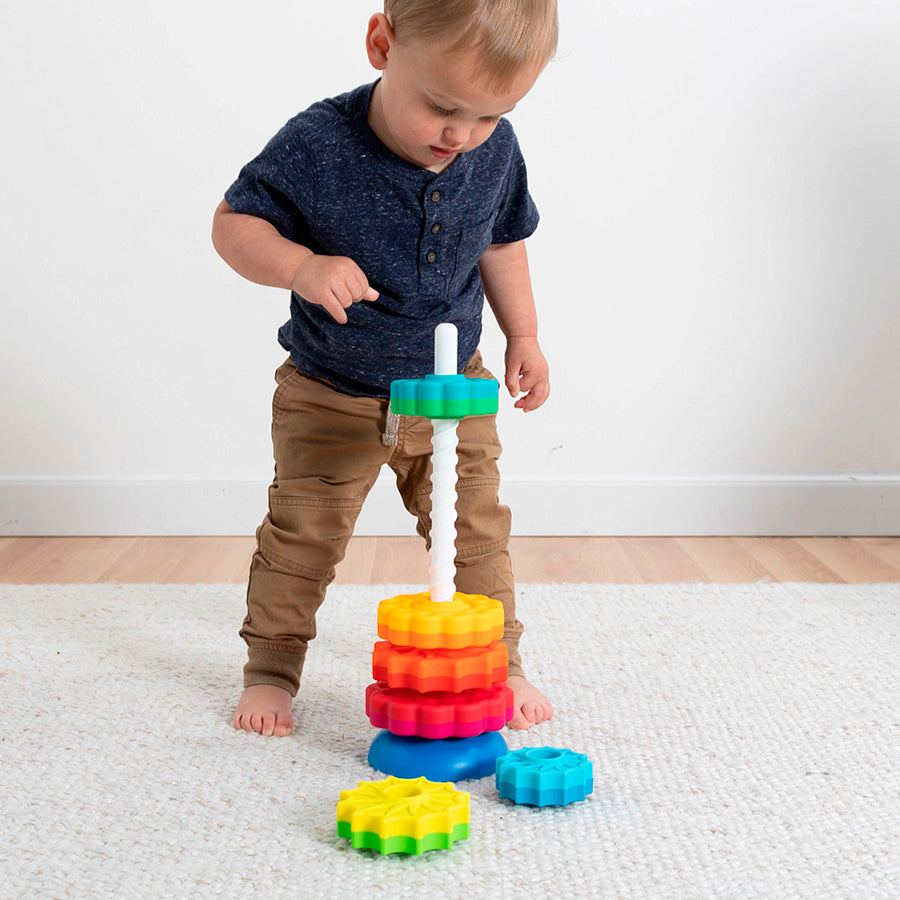 A child with light skin tone and short dark blonde hair stands over the SpinAgain as one piece drops down the tower.