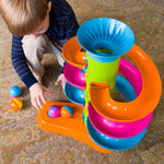 A child crouches to move the balls from the RollAgain Tower.