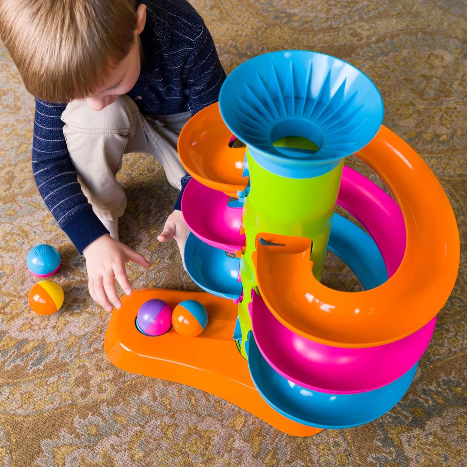 A child crouches to move the balls from the RollAgain Tower.