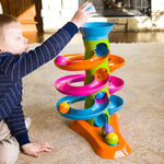 A child drops a ball into the top of the RollAgain Tower.