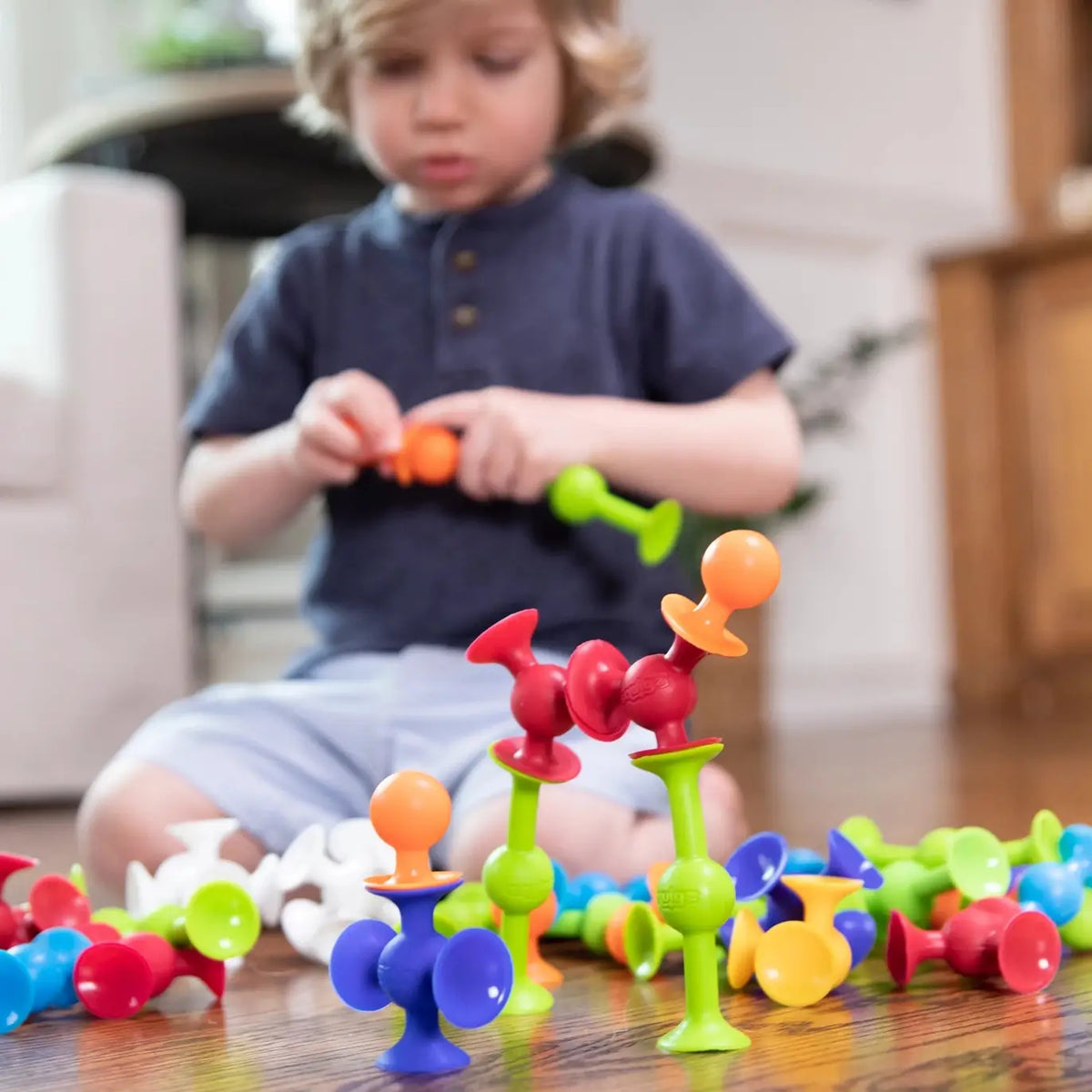 A child pulls apart Squigz.