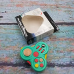 The green Fidget Pad 12-in-1 Fidget Controller.
