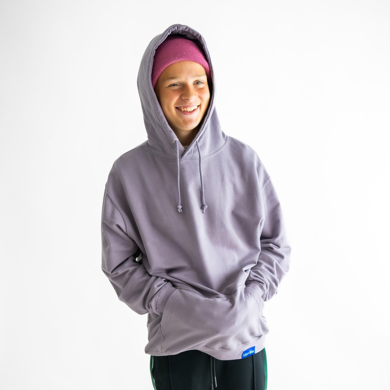 Someone smiles with the hood up on their Peaceful Purple Fidget Wear Fidget Hoodie for Adults.