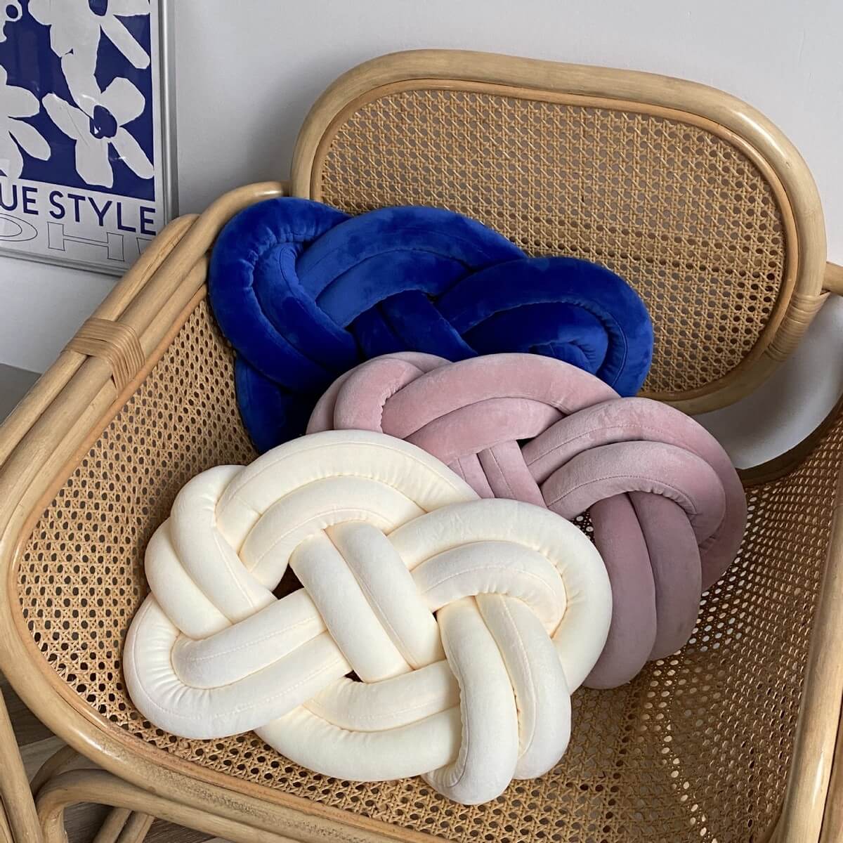 Three Fried Dough Twist Plush Sensory Pillows on a wicker chair.