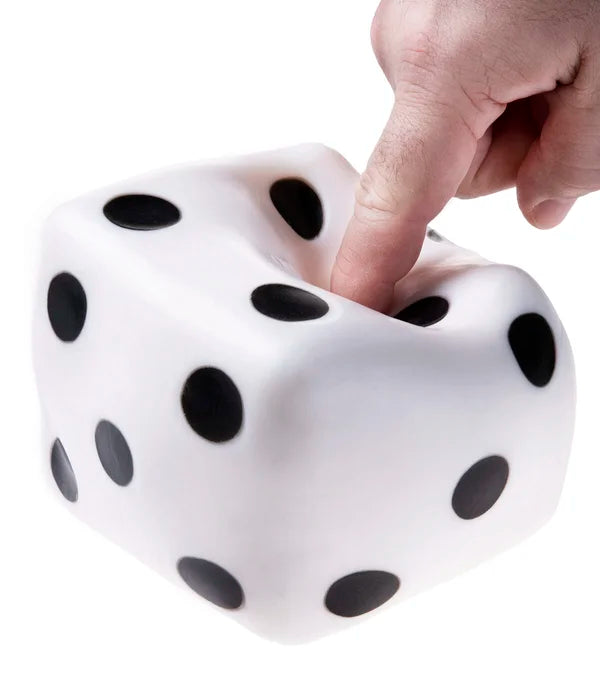 A hand with light skin tone is poking the Giant Dice Stress Ball with their pointer finger.