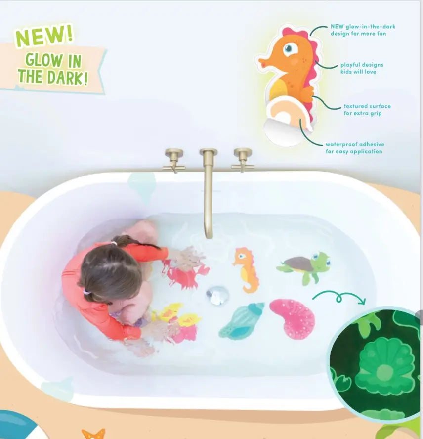 A camera looks down on a bathtub scene - a child is wearing a long-sleeved swim suit in a full tub and touching the textured Guppy Grips on the bottom of the tub.