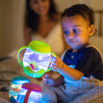 A child holds up the Green Mini Sensory Jar.