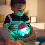 A toddler holds up a glowing pink Glo Pals Mini Sensory Jar and Silicone Fun Filler.