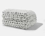 A folded Soft Grey Gravity Chunky Weighted Blanket.