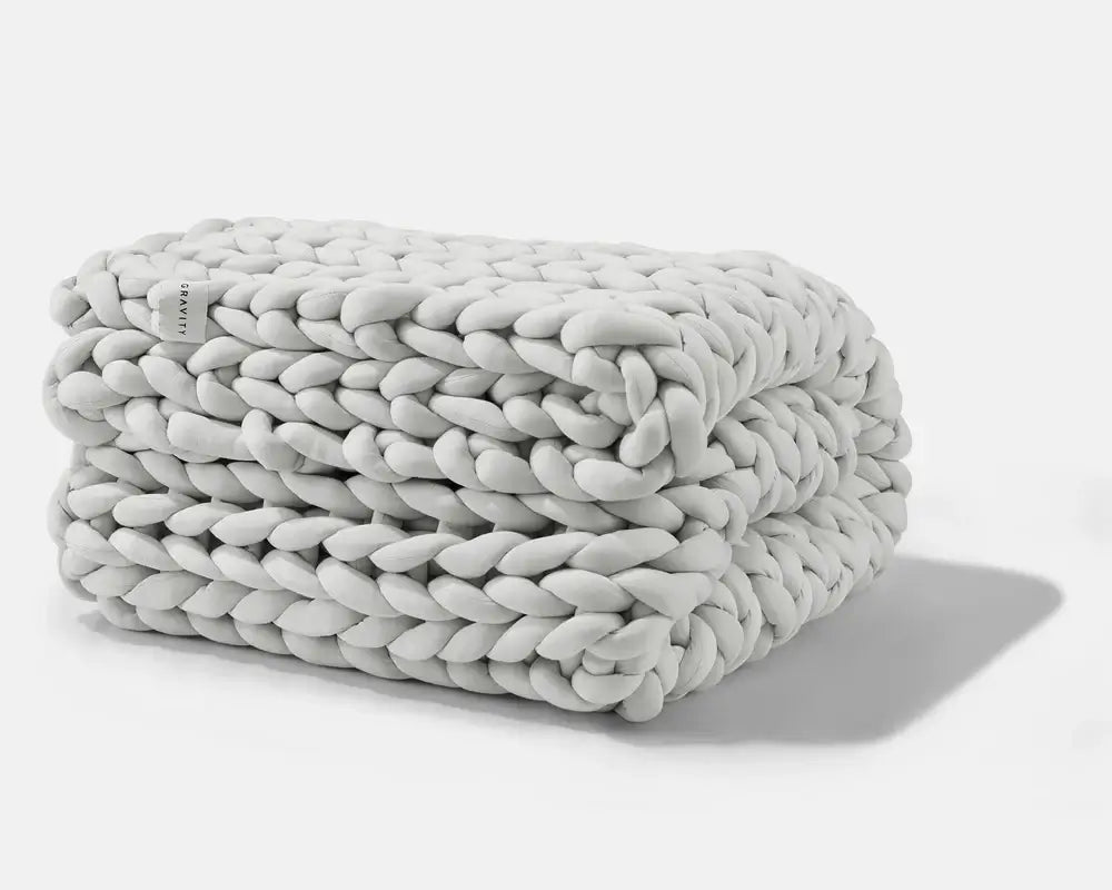 A folded Soft Grey Gravity Chunky Weighted Blanket.