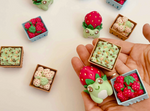 A variety of clickers, which include the Strawberry Frog Clicker Fidget Keychain.