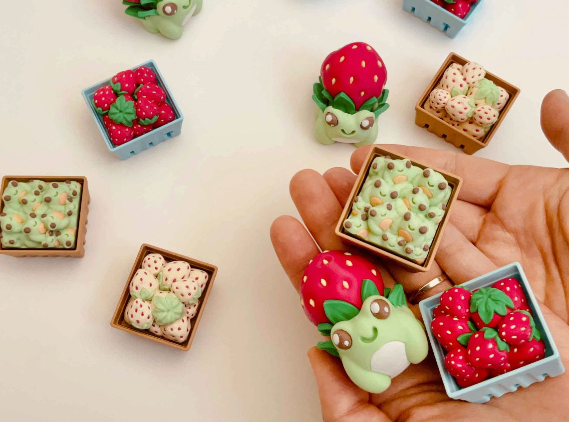 A variety of clickers, which include the Strawberry Frog Clicker Fidget Keychain.