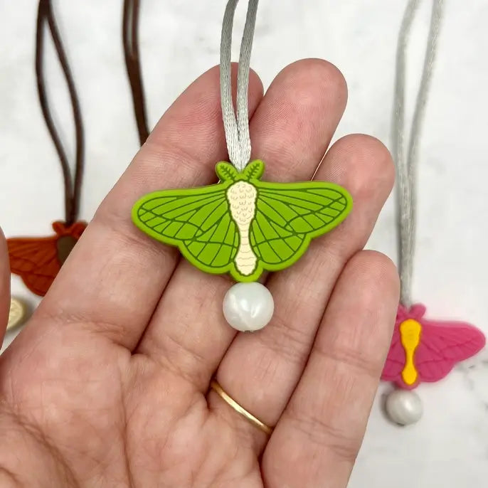 The green chewy Moth Fidget Necklace.