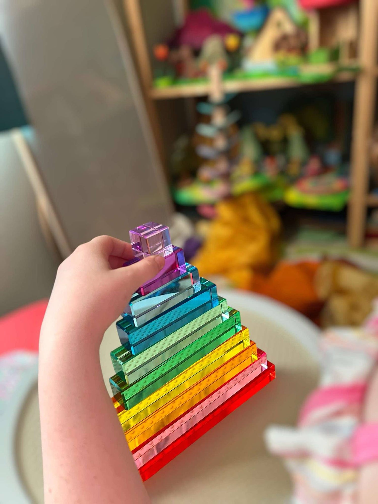 A hand touches the top two blocks on a stack of 10-Piece Crystal Clear Pyramid Lucite Blocks.