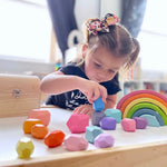 A child plays with the 16-Piece Wooden Balancing Stones Stacking Blocks.