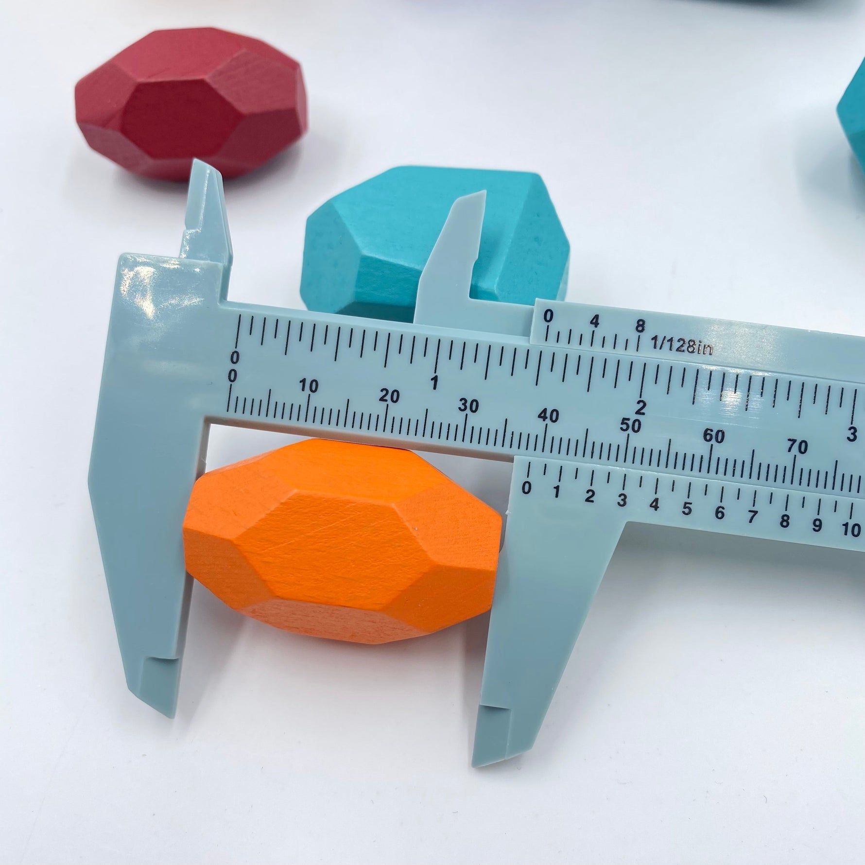 An Orange Wooden Balancing Stone Stacking Block being measured in a blue device.