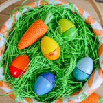 The Fun With Sounds Wooden Eggs sit in an easter basket with a paper carrot.