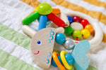 The  Rattlefish Baby Wooden Rattle next to two other toys.